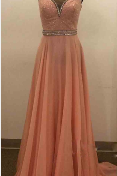 A ball gown with a pink beaded necklace. Evening dress